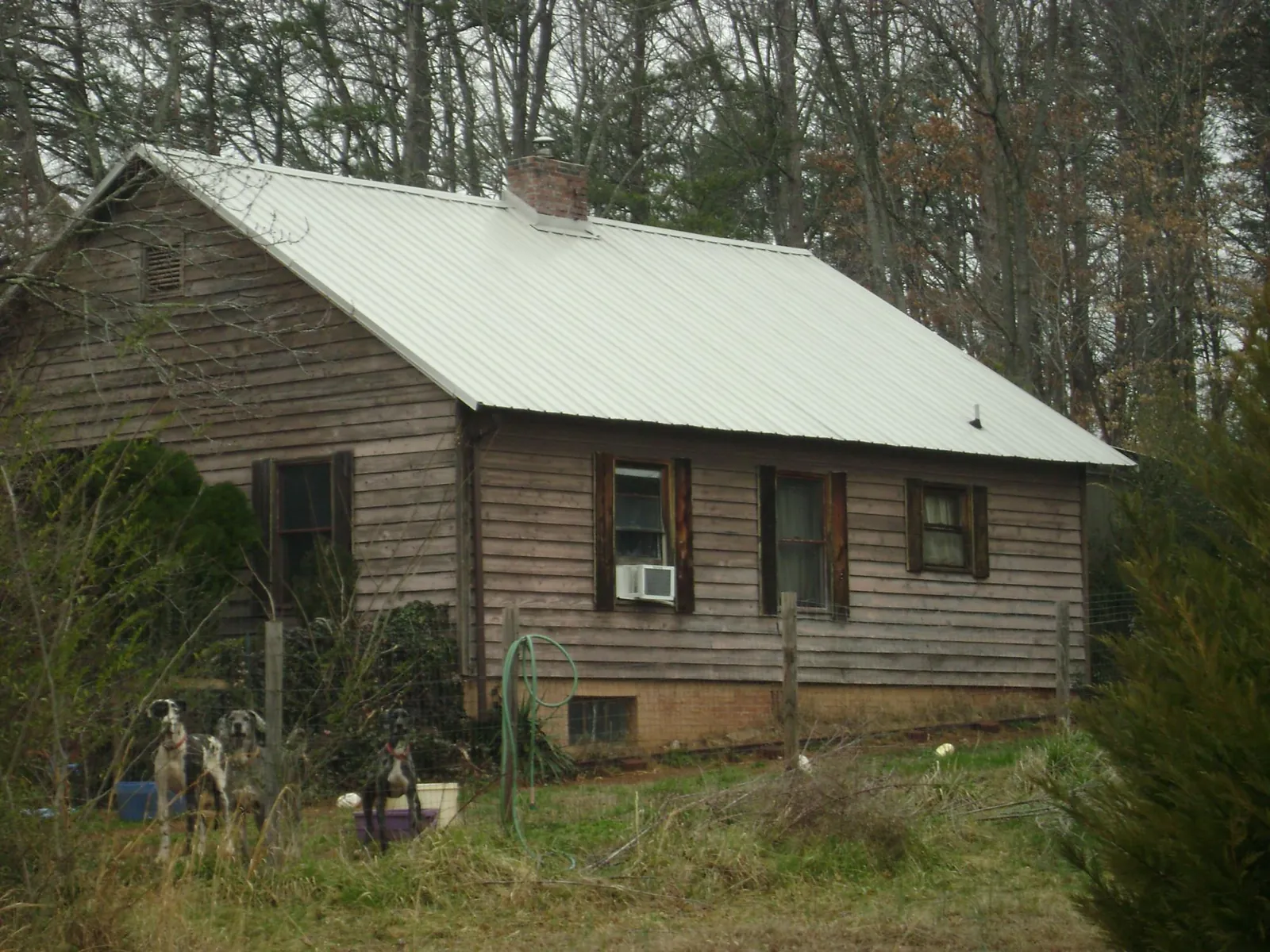 White metal roof on an old wood sided farmhouse, from a Metal Roof Installation job in Huntertown